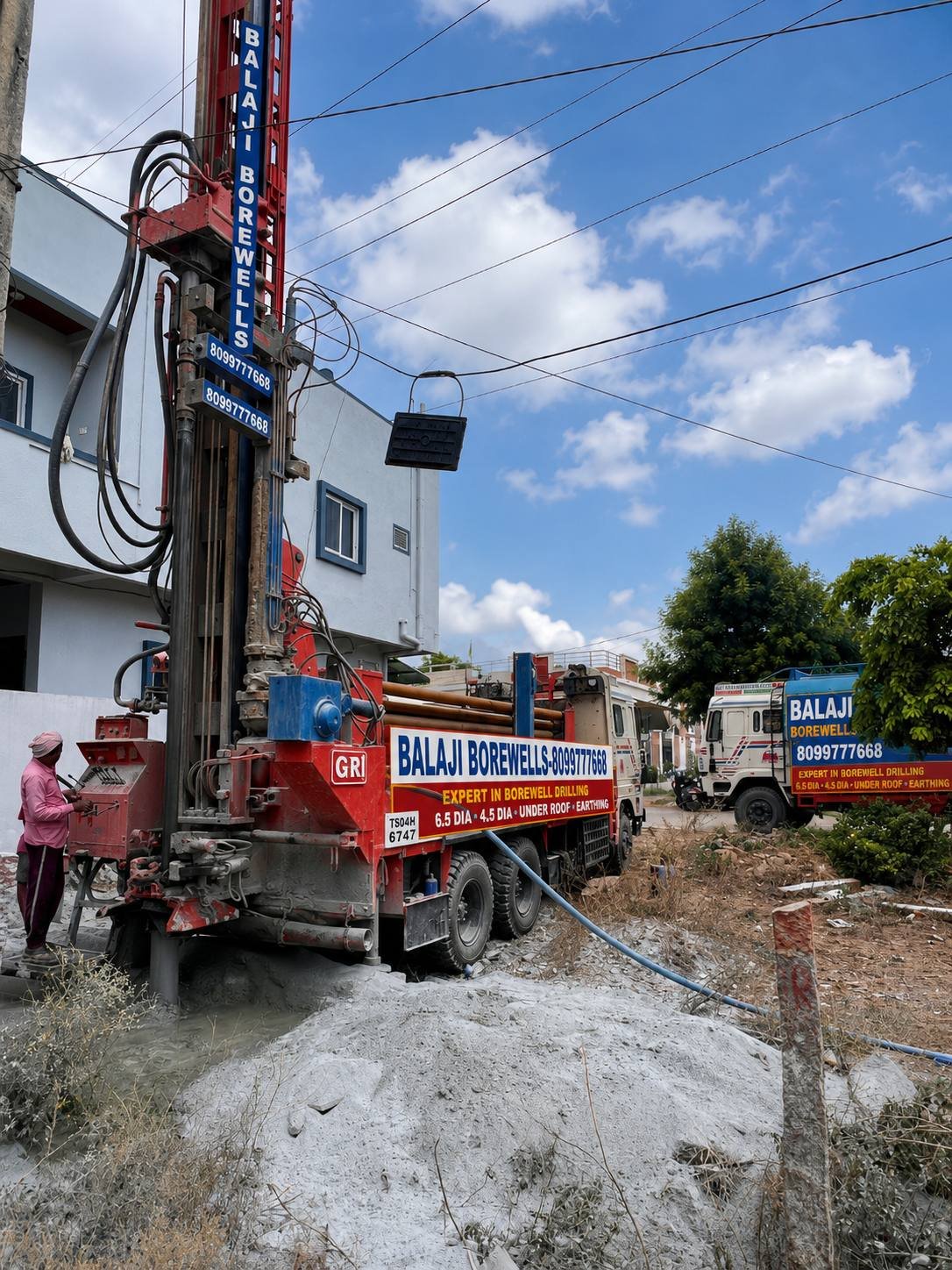 Balaji Borewells drilling rig with 6.5 dia and 4.5 dia under roof and earthing signage on site